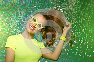 Trendy girl with bright green neon accessories. Model in a disco nightclub. Woman at a theme party in the rays of light