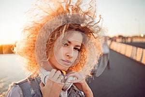 Trendy girl with large headphones on a city walk, close up.