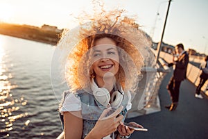 Trendy girl with large headphones on a city walk, close up.