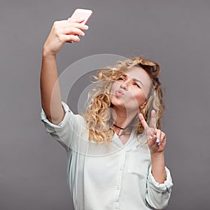 Trendy girl taking selfie in studio
