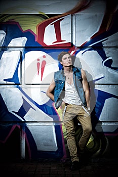 Trendy guy against a wall with graffiti