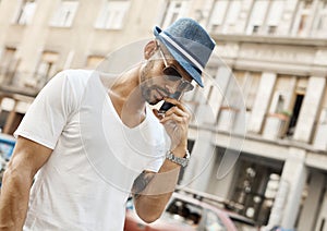 Trendy guy on the phone on street in city