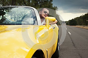 Trendy guy in sunglasses driving