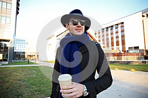 Trendy handsome young man in autumn fashion standing in urban environment.