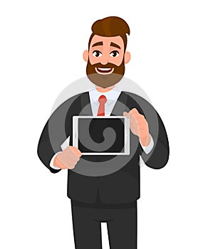 Trendy, happy young bearded business man showing/holding blank screen of digital tablet computer in hands. Modern technology.