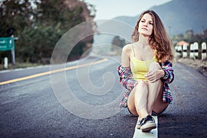 Trendy Hipster Girl Relaxing on the road at the day time.