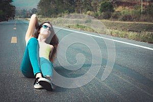 Trendy Hipster Girl in the sunglasses Relaxing on the road at th