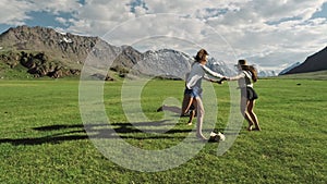 Trendy Hipster Girls having fun outdoor. Three cute women are whirling on green grass. Best friends.