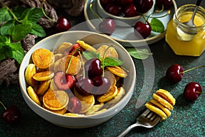 Trendy home breakfast. Mini pancakes, honey and cherries