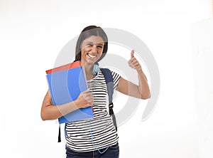 Trendy latin student girl holding notepad folder and book carrying backpack smiling happy