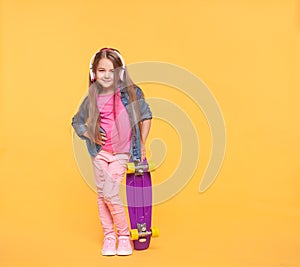 Trendy little girl child listening to music in headphones