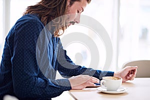 Trendy male hipster busy using his tablet on the table