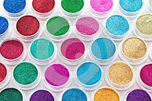 Trendy multicolored glitter in jars. Shimmer, sparkle for makeup, manicure. Shiny powder. Bright pigments. Cosmetic.