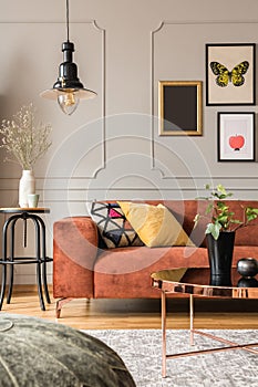 Trendy posters in elegant grey living room interior with brown corner sofa