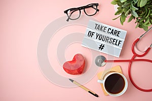 Trendy self care concept with light box, heart shape and stethoscope on pink background