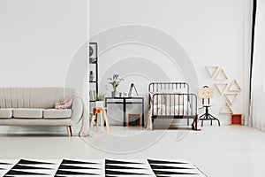 Trendy sofa in scandinavian design kid`s bedroom with industrial furniture and patterned black and white rug on the floor,