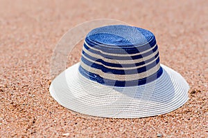 Trendy sunhat lying on beach sand
