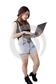 Trendy teenage girl with laptop in studio