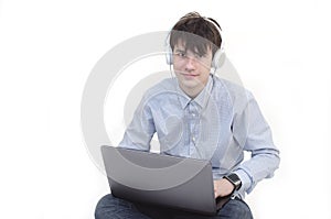 Trendy teenager using a laptop and listening to music