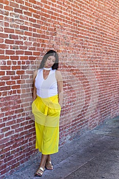 Trendy thoughtful woman leaning against a wall