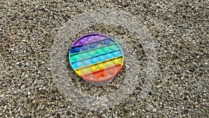 Trendy toy, silicone antistress, pop it fidgets in sand outdoors