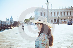 Trendy traveller woman in floral dress enjoying promenade