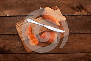 Trendy ugly organic carrot from home garden bed on barn wood table, Australian grown. Color-toning effect applied