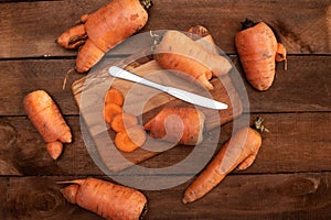 Trendy ugly organic carrot from home garden bed on barn wood table, Australian grown. Color-toning effect applied