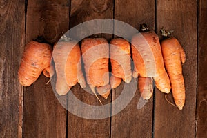 Trendy ugly organic carrot from home garden bed on barn wood table, Australian grown. Color-toning effect applied