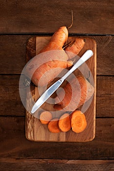 Trendy ugly organic carrot from home garden bed on barn wood table, Australian grown. Color-toning effect applied