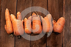 Trendy ugly organic carrot from home garden bed on barn wood table, Australian grown. Color-toning effect applied