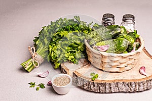 Trendy ugly organic cucumbers in a basket, garlic cloves, parsley greens, mustard, spices