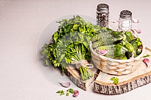 Trendy ugly organic cucumbers in a basket, garlic cloves, parsley greens, mustard, spices