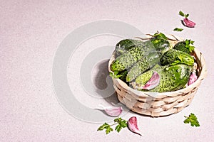 Trendy ugly organic cucumbers, garlic cloves, parsley greens in a basket