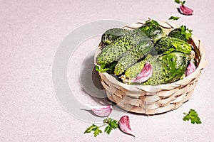 Trendy ugly organic cucumbers, garlic cloves, parsley greens in a basket