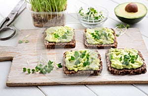 Trendy wholegrain toasts with avocado and microgreen photo