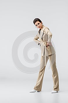 trendy woman in beige pantsuit posing
