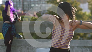 Trendy woman dancing and having fun outside on a city bridge. Energetic African hip hop performer practicing her dance