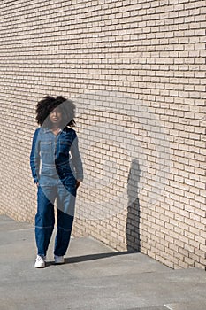 Trendy Woman in Denim Attire Against Brick Wall