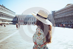 Trendy woman in floral dress with hat exploring attractions photo