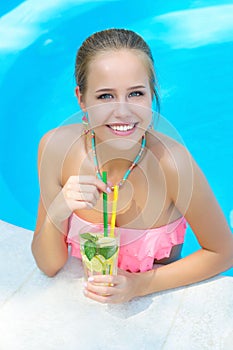 Trendy woman with lemonade in the pool