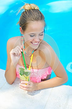 Trendy woman with lemonade in the pool