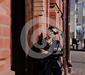 Trendy woman in luxury sunglasses, leather jacket