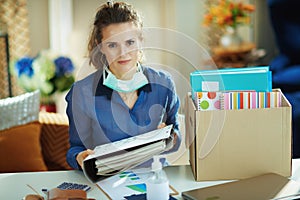 Trendy woman with medical mask organising home office