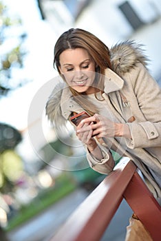 Trendy woman outdoors using smartphone