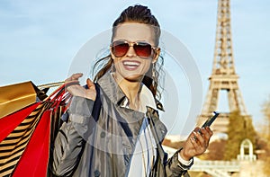 Trendy woman in Paris looking into distance and writing sms