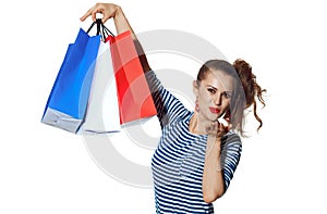 Trendy woman with shopping bags on white blowing air kiss