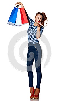 Trendy woman with shopping bags on white blowing air kiss