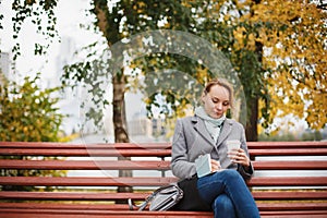 Trendy woman in stylish coat sitting