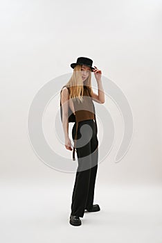 Trendy young caucasian girl in hat posing sideways